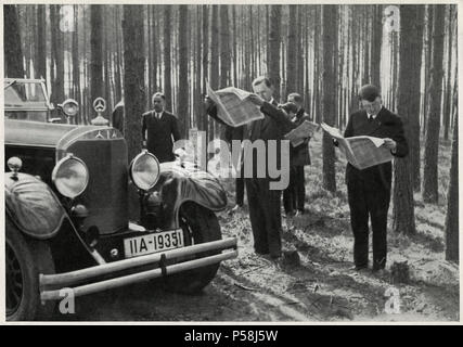 Adolf Hitler und Entourage steht neben seinem Mercedes beim Lesen der Zeitungen im Wald, Deutschland, Anfang der 30er Jahre Stockfoto