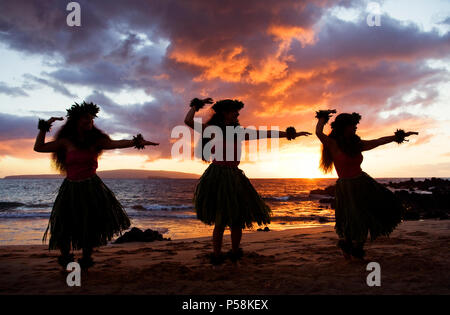 Drei Hula-Tänzer bei Sonnenuntergang am Palauea Beach, Maui, Hawaii. Stockfoto