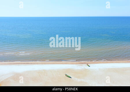 Gelb Sand Strand der Ostsee mit zwei hölzerne Fischerboote und dem blauen Meer bis zum Horizont Stockfoto