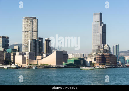 Skyline von Kowloon in Tsim Sha Tsui Blick über den Victoria Harbour in Hong Kong an einem sonnigen Tag in China SAR. Stockfoto