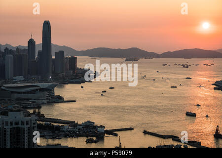 Einen atemberaubenden Blick auf den Sonnenuntergang über dem Victoria Harbour in Hong Kong mit der Wolkenkratzer von Hong Kong Island in der Linken in China Stockfoto