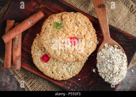 Hausgemachte oatmeal Cookies, Zimtstangen und Haferflocken auf einem Holztisch. Flach, Ansicht von oben Stockfoto
