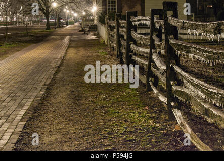 Williamsburg Ice Storm Ergebnisse in der Nacht gesehen. Eiszapfen tropft eine geteilte Schiene Zaun auf Herzog von Gloucester Straße im Colonial Williamsburg. Stockfoto