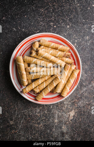 Süße Schokolade waffelröllchen an der Platte. Stockfoto