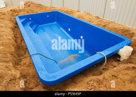 Installation Kunststoff GFK-Pool in der Erde zu Haus Hinterhof. Baustelle Stockfoto