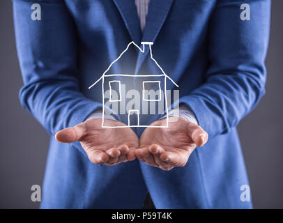 Geschäftsmann mit einem deawn Haus auf der Hand. Stockfoto