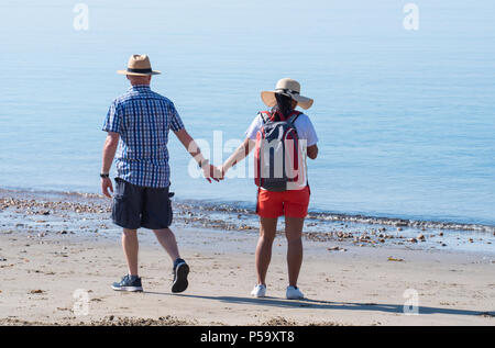 Lyme Regis, Dorset, Großbritannien. 26. Juni 2018. UK Wetter: Sehr heiß und sonnig in Lyme Regis. Ein paar nehmen Sie morgens einen Spaziergang am Strand entlang in der heißen Sonne im Badeort Lyme Regis am heißesten Tag des Jahres so weit. Credit: Celia McMahon/Alamy Leben Nachrichten. Stockfoto