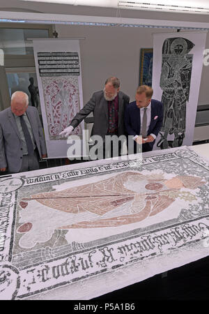 26 Juni 2018, Halle/Saale, Deutschland: Michael Ruprecht (R-L), Leiter des Archivs der Martin-Luther-Universität Halle und der Sammler Reinhard Lampe aus Hamburg, sowie Kevin Hering aus London Blick an einem Reiben von Wilhelm Westval (1443-1509), Bischof von der Luebecker grabstein an der Universität Halle. Hering und Lampe gelten als Experten auf dem Gebiet der Messing Durchschläge und haben Ihre persönlichen Sammlungen an der Universität Halle Archiv gespendet. Es handelt sich 600 detaillierte Abdrücke von Grabsteinen aus ganz England und Deutschland. Die Ursprünge der Brass rubbing als eine Form der documenta Stockfoto