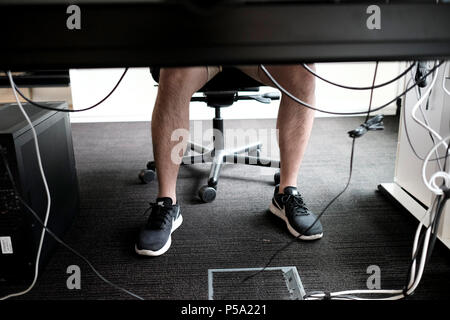 Deutschland, Berlin. 15 Juni, 2018. Ein Mann in kurzen Hosen an seinem Arbeitsplatz. Credit: Fabian Sommer/dpa/Alamy leben Nachrichten Stockfoto