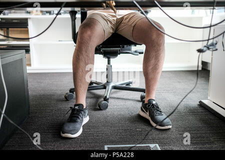 Deutschland, Berlin. 15 Juni, 2018. Ein Mann in kurzen Hosen an seinem Arbeitsplatz. Credit: Fabian Sommer/dpa/Alamy leben Nachrichten Stockfoto