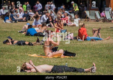 Green Park, London. 26 Jun, 2018. UK Wetter: Menschen beider Geschlechter abstreifen und ihre Mittagspause in der warmen und sonnigen Bedingungen im Green Park genießen. Credit: Guy Bell/Alamy leben Nachrichten Stockfoto
