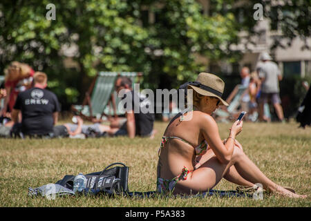 Green Park, London. 26 Jun, 2018. UK Wetter: Social Media geht auf beim Sonnenbaden - Menschen ihre Mittagspause in der warmen und sonnigen Bedingungen im Green Park genießen. Credit: Guy Bell/Alamy leben Nachrichten Stockfoto