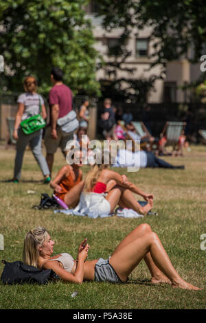 Green Park, London. 26 Jun, 2018. UK Wetter: Social Media geht auf beim Sonnenbaden - Menschen ihre Mittagspause in der warmen und sonnigen Bedingungen im Green Park genießen. Credit: Guy Bell/Alamy leben Nachrichten Stockfoto