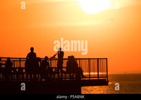 Aberystwyth, Großbritannien. 26 Juni, 2018. UK UK Wetter: einen spektakulären Sonnenuntergang über dem Meer Pier und Cardigan Bay in Aberystwyth am Ende eines Tages, wenn die Temperatur auf 28 °C in der Stadt und über 30 c in Porthmadog, gerade lang der Küste im Norden von Wales die britische Position wird in einem mini Hitzewelle mit Temperaturen weit über 30 Grad Celsius prognostiziert durch die Mittwoch oder Donnerstag Photo Credit: Keith Morris/Alamy leben Nachrichten Stockfoto