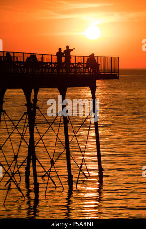 Aberystwyth, Großbritannien. 26 Juni, 2018. UK UK Wetter: einen spektakulären Sonnenuntergang über dem Meer Pier und Cardigan Bay in Aberystwyth am Ende eines Tages, wenn die Temperatur auf 28 °C in der Stadt und über 30 c in Porthmadog, gerade lang der Küste im Norden von Wales die britische Position wird in einem mini Hitzewelle mit Temperaturen weit über 30 Grad Celsius prognostiziert durch die Mittwoch oder Donnerstag Photo Credit: Keith Morris/Alamy leben Nachrichten Stockfoto