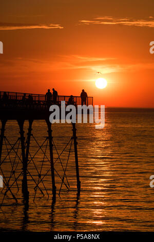 Aberystwyth, Großbritannien. 26 Juni, 2018. UK UK Wetter: einen spektakulären Sonnenuntergang über dem Meer Pier und Cardigan Bay in Aberystwyth am Ende eines Tages, wenn die Temperatur auf 28 °C in der Stadt und über 30 c in Porthmadog, gerade lang der Küste im Norden von Wales die britische Position wird in einem mini Hitzewelle mit Temperaturen weit über 30 Grad Celsius prognostiziert durch die Mittwoch oder Donnerstag Photo Credit: Keith Morris/Alamy leben Nachrichten Stockfoto