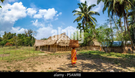 Malerische ländliche Indien village Szene mit Tribal Frau, die trockenen Blätter in das Dorf bei Baratang Insel Andaman Stockfoto