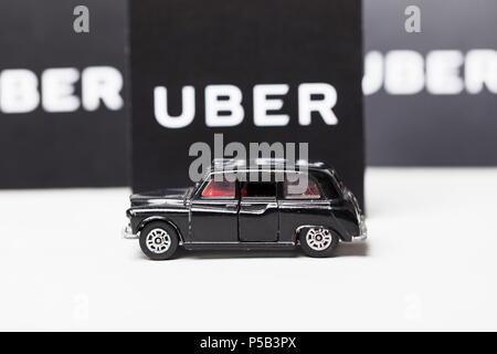 London, UK, 23. MÄRZ 2017: ein Foto des Uber Logo mit einem schwarzen London Style taxi Spielzeugauto. Uber ist ein beliebter Stil taxi transport Service App Stockfoto