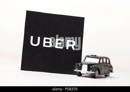 London, UK, 23. MÄRZ 2017: ein Foto des Uber Logo mit einem schwarzen London Style taxi Spielzeugauto. Uber ist ein beliebter Stil taxi transport Service App Stockfoto