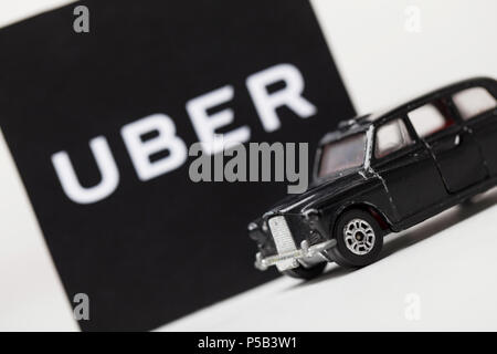 London, UK, 23. MÄRZ 2017: ein Foto des Uber Logo mit einem schwarzen London Style taxi Spielzeugauto. Uber ist ein beliebter Stil taxi transport Service App Stockfoto