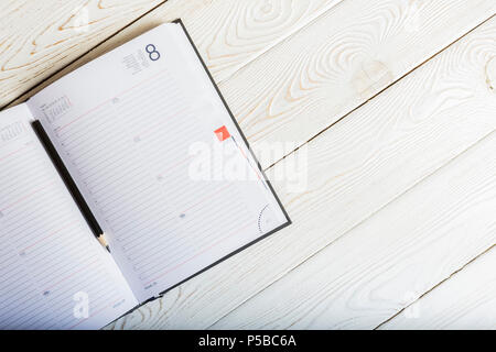 Notebook auf einem Holztisch, Ansicht von oben. Stockfoto