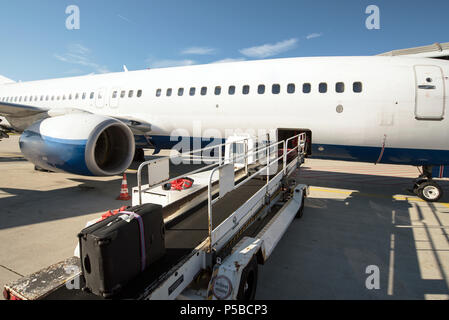 Das bodenpersonal Handhabung ein Flugzeug vor dem Abflug am Flughafen - Laden von Gepäck Stockfoto