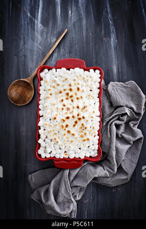 Süsse Kartoffel Auflauf gebacken mit mini Marshmallows für Thanksgiving Tag bereit. Ein Stück fehlt in der Ecke. Von oben geschossen. Stockfoto