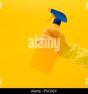 Hand in gelben Gummihandschuh mit Reinigungsmittel Stockfoto