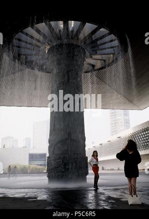 MODELO PUBLICITARIA REALIZANDO UNA SESSION DE FOTOS EN EL VESTIBULO DEL MUSEO CON LA FUENTE DE TLALOC O DIOS DE LA LLUVIA. Lage: MUSEO NACIONAL DE ANTROPOLOGIA, Mexiko-stadt, CIUDAD DE MEXICO. Stockfoto