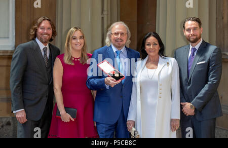 Sänger und Songwriter Barry Gibb, mit seiner Frau Linda und Kinder, Michael (rechts), Alexandra und Ashley (Links) im Buckingham Palace, London, nachdem er vom Prinzen von Wales bei einer Ordensverleihung zum Ritter geschlagen. Stockfoto