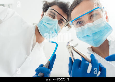 Lustige Zahnärzte mit ihren Tools aus der Sicht Stockfoto