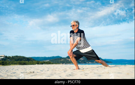 Ältere Menschen tun Stretching Übungen am Strand, Sport Abstract Stockfoto
