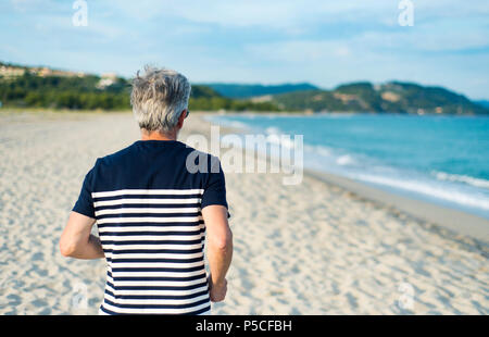 Älterer Mann laufen am Strand, gesunden Lebensstil Stockfoto