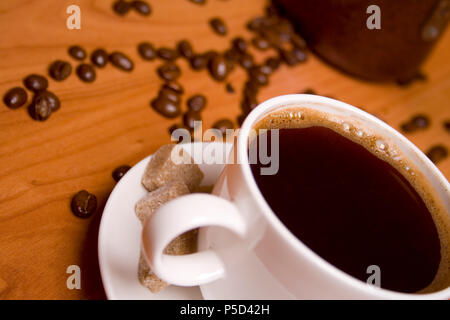 Tasse Kaffee, Caffee, Zucker und Bohnen auf hölzernen Tisch Stockfoto