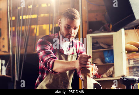 Tischler arbeiten mit Flugzeug und Holz bei workshop Stockfoto