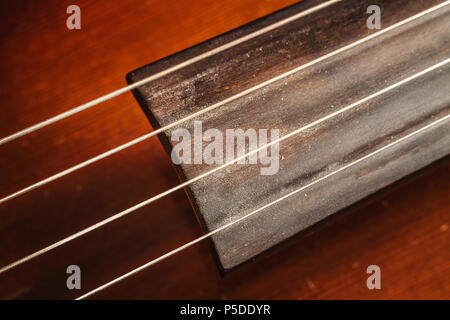 Details eines alten staubigen Cello, Detailansicht auf Zeichenketten und Körper. Stockfoto