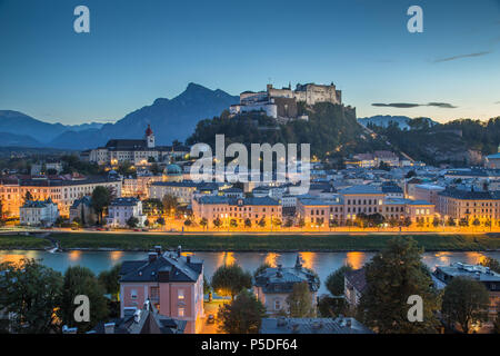 Antenne Panoramablick auf die Altstadt von Salzburg mit berühmten Festung Hohensalzburg in mystische Abenddämmerung während der Blauen Stunde in der Dämmerung in autolöscher Stockfoto