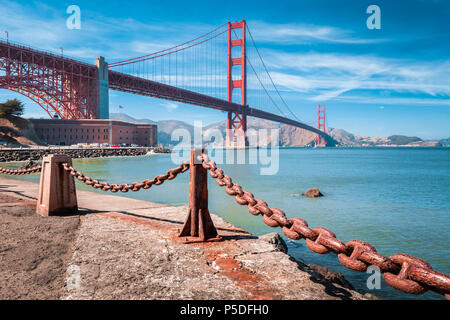 Klassische Ansicht der berühmten Golden Gate Bridge mit Fort Point National Historic Site an einem schönen sonnigen Tag mit blauen Himmel und Wolken, San Francisco, USA Stockfoto