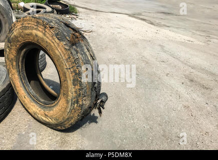 Burst schmutzigen Reifen von Garage auf der Straße. Auto Teil reparieren, Ersatzteile, Uvv-Konzept. Stockfoto