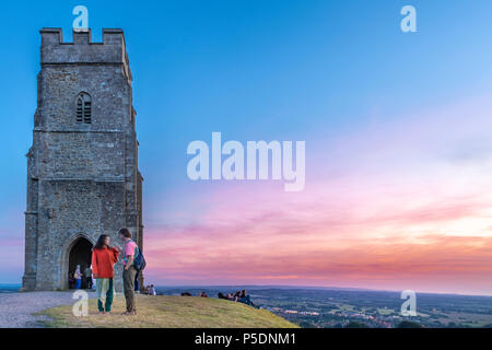 UK Wetter - auf dem Glastonbury Tor, eine Gruppe von Menschen versammeln sich einen wunderschönen Sonnenuntergang über dem Somerset Levels Zeuge, wie der Westen von England se ist Stockfoto