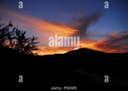 Eine atemberaubende Safari sunset in der Südafrikanischen Wüste schafft eine erstaunliche Hintergrund für alle Medien Präsentation. Stockfoto