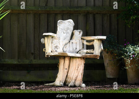 Gestaltete Holz Bank vor einem Zaun ein sonniger Tag im Sommer in einem englischen Garten. Stockfoto