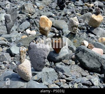 Große Steine und Kiesel Balancieren auf einem Kieselstrand, St Ives, Cornwall, England, Großbritannien Stockfoto