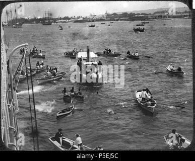 Barbados. Hafen Szene; Steam starten, indem mehrere Ruderboote umgeben. Waterfront und zwei große Segelschiffe im Hintergrund. Viele Menschen in Booten.. 1902. N/A 169 Barbados YORYM-TA 0183 Stockfoto