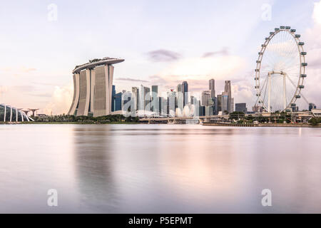 Sonnenaufgang über der Skyline der Innenstadt von Singapur als über vom Wasser aus dem Garten Osten gesehen. Singapur. Stockfoto