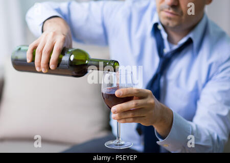 Alkoholische gießen Rotwein in Glas zu Hause Stockfoto