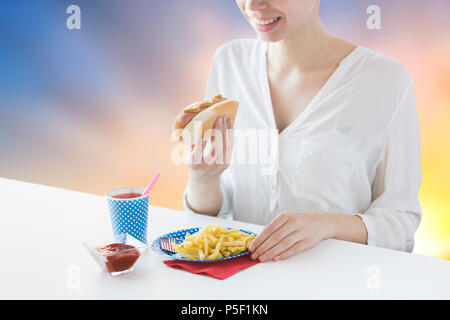 Nahaufnahme von Frau essen Würstchen und Pommes frites Stockfoto