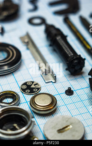 Teile sind vollständig demontiert alten retro Film SLR Kamera auf Millimeterpapier, close-up Stockfoto