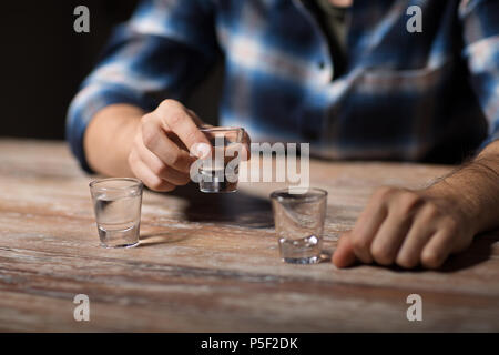 Hände von alkoholischen Wodka zu trinken Schüsse in der Nacht Stockfoto