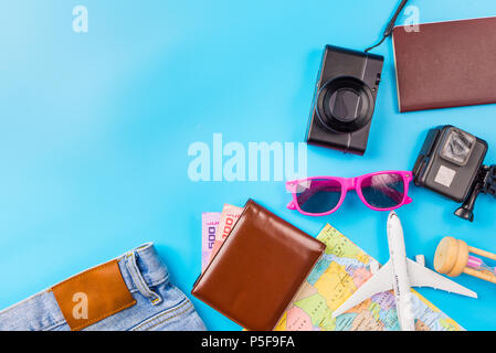 Reise Zubehör Kostüme Konzept für Sommerurlaub Reise. Pässe, Gepäck, Karte, Smartphone, Sonnenbrille, Kamera, Notizen, Jean auf Blau. Stockfoto